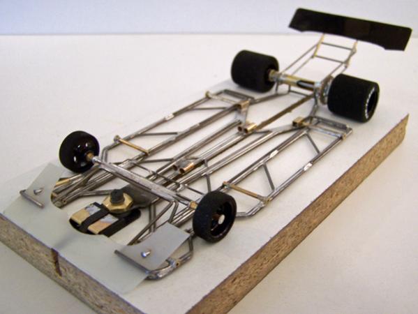 1213-D
Adaptation of 1213-design for 4-1/2 classic stock car body; all-wire no-rules chassis (no brass plate or sheet) with torsional wire side pans and a narrower separate center-guide section; anglewinder drive. Front and rear spoilers were mounted directly to the chassis (not the body).