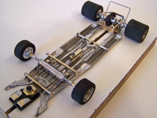 A208
Ret-ro rules in-line open-wheel chassis; 1226-based design; all-wire frame with damper main rails, separate torsional center-guide section attached to motor box built to be as narrow as possible using only four side-by-side pieces of 0.047 wire, separate left-right torsional wire-frame rails attached to motor box for front-axle uprights, torsional wire side pans, and variable spring-wire tension system between center-guide section / front-axle uprights for "chassis tuning".